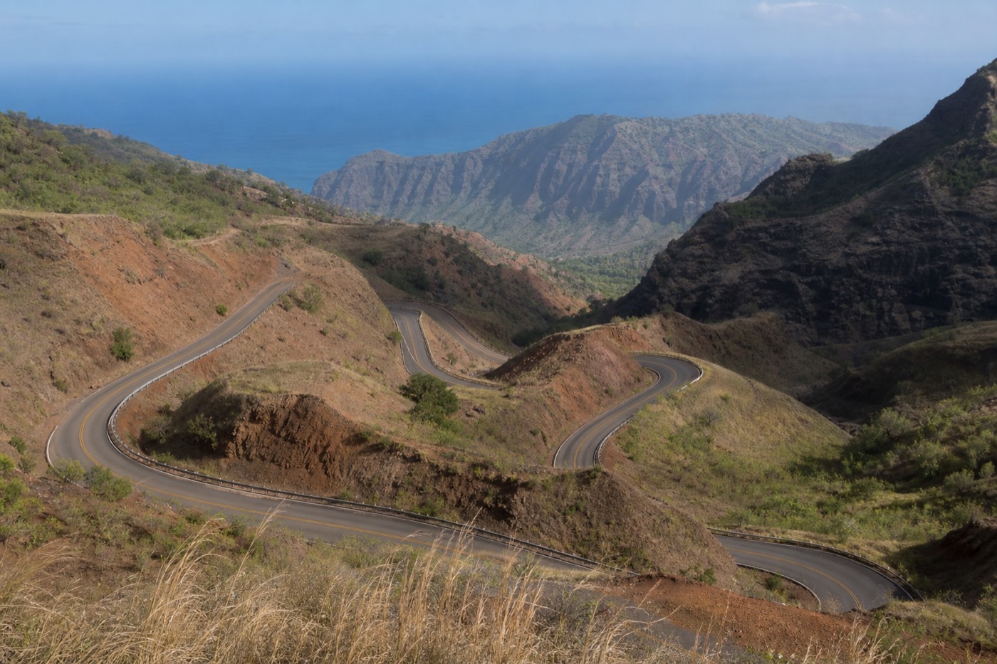 The winding Route 550 climbing above the red cliffs of Waimea Canyon on Kauai's west side