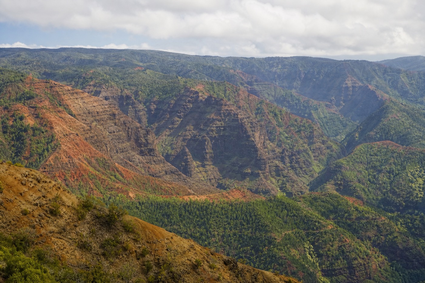 Split view of a canyon van tour, a Nā Pali catamaran, and a helicopter over Kauai